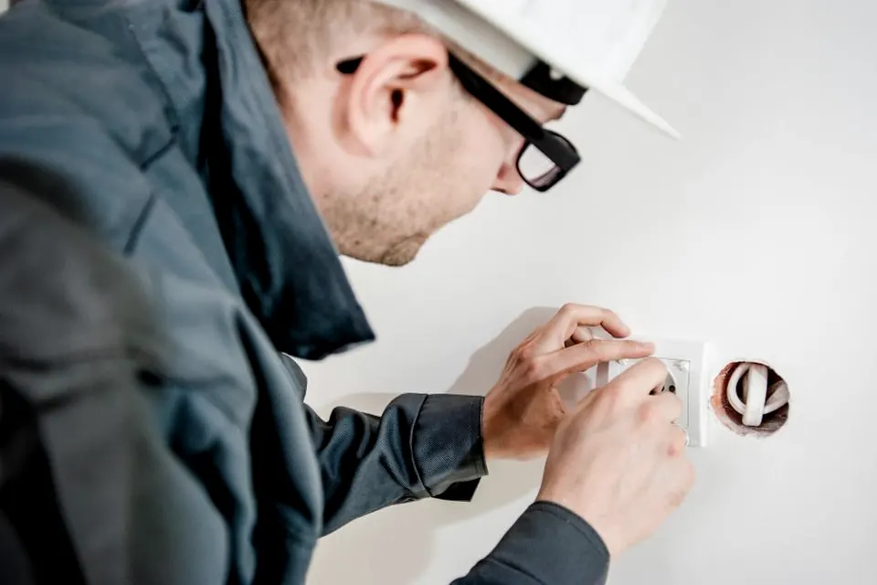 An electrician fitting a wall socket.